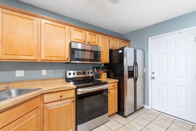 kitchen with stainless steel appliances and light tile patterned flooring