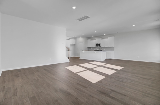 unfurnished living room with sink and dark hardwood / wood-style flooring