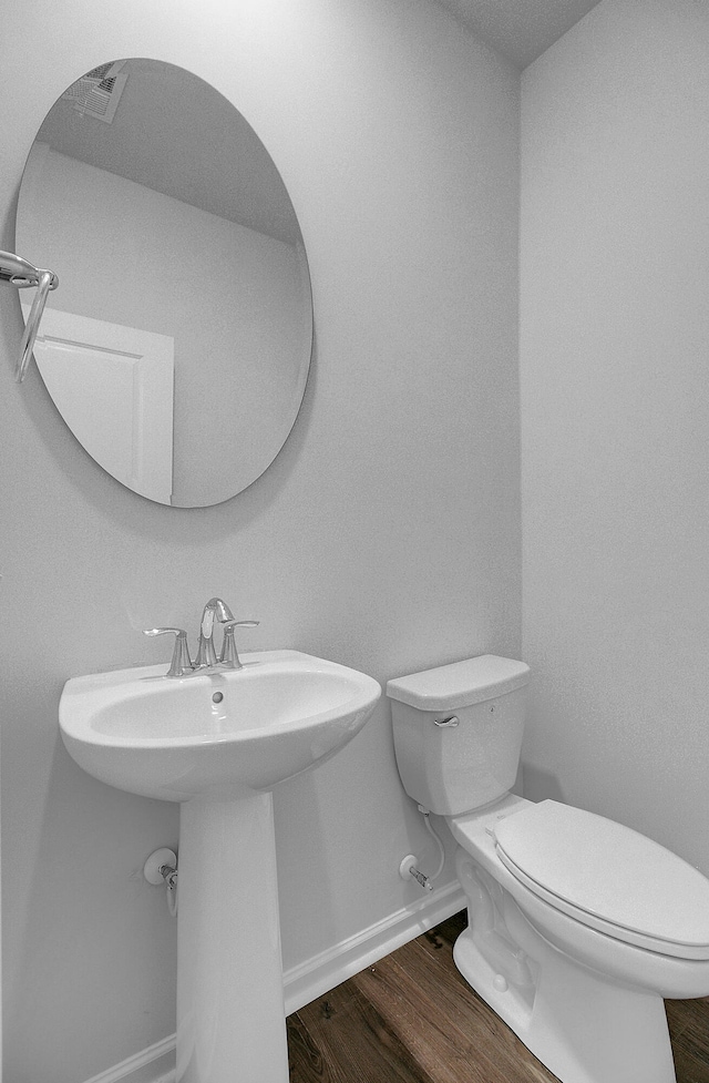 bathroom with toilet, sink, and hardwood / wood-style flooring