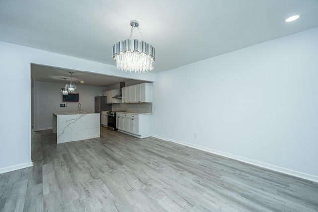 133 Marion Rd, Summerville, SC 29486 - unfurnished living room featuring a chandelier, baseboards, recessed lighting, a sink, and light wood-style floors