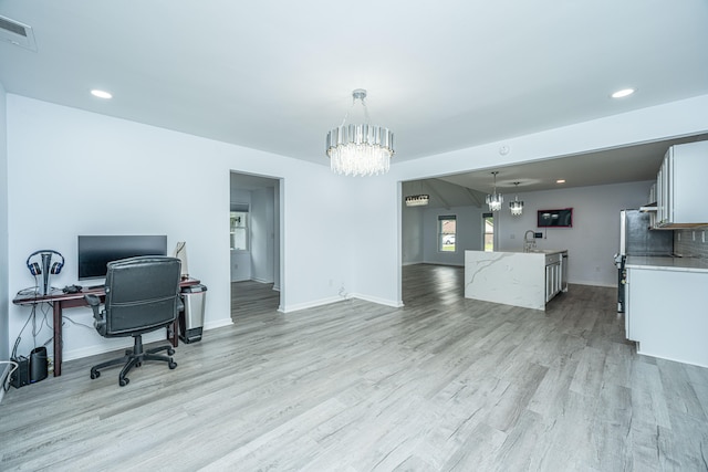 office space featuring light hardwood / wood-style flooring, an inviting chandelier, and sink