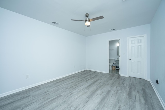 unfurnished bedroom featuring ceiling fan, a closet, light wood-type flooring, and connected bathroom