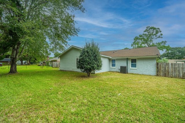 back of house featuring central AC and a lawn