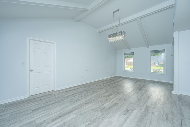 empty room featuring light hardwood / wood-style flooring, a chandelier, and vaulted ceiling with beams