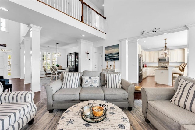 1003 Jervey Point Rd, Wando, SC 29492 - living area with decorative columns, ornamental molding, wood finished floors, a towering ceiling, and recessed lighting