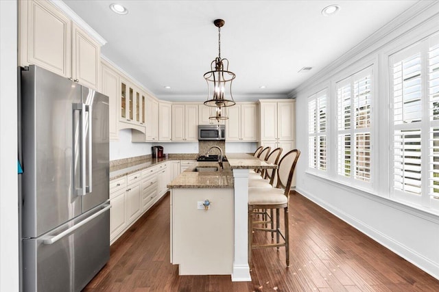 1003 Jervey Point Rd, Wando, SC 29492 - kitchen featuring appliances with stainless steel finishes, light stone counters, a breakfast bar, pendant lighting, and a center island with sink