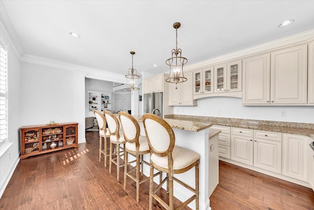 1003 Jervey Point Rd, Wando, SC 29492 - kitchen featuring stainless steel refrigerator, a kitchen breakfast bar, hardwood / wood-style flooring, crown molding, and glass insert cabinets