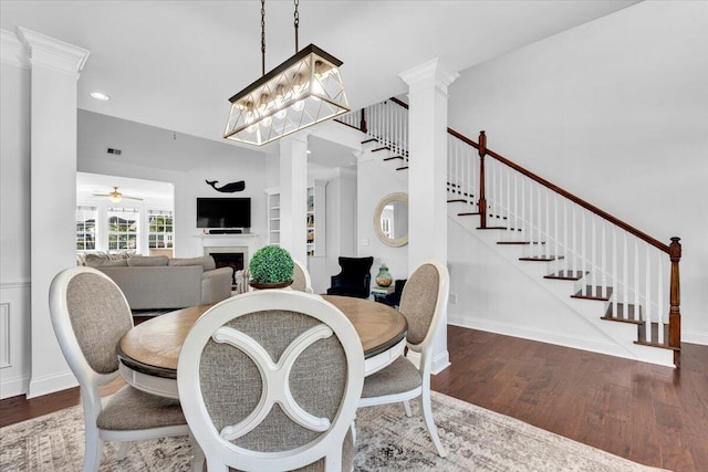 1003 Jervey Point Rd, Wando, SC 29492 - dining space with ornate columns, a fireplace, stairs, wood finished floors, and a ceiling fan