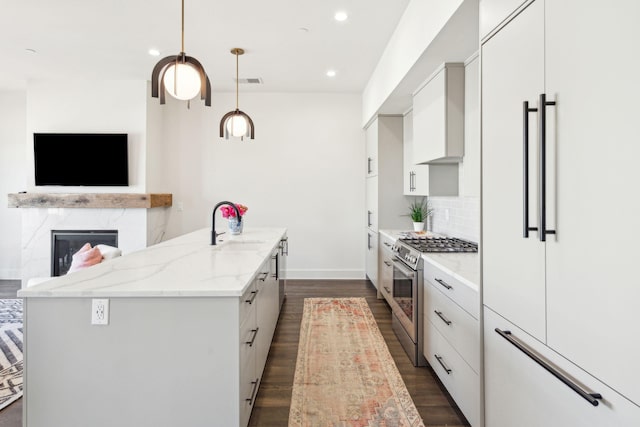 kitchen with white cabinetry, light stone countertops, decorative light fixtures, and premium appliances