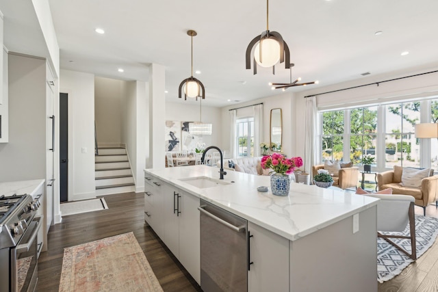 kitchen featuring pendant lighting, white cabinetry, appliances with stainless steel finishes, and dark wood-type flooring