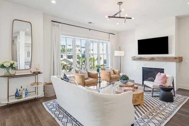 living room featuring dark hardwood / wood-style flooring, a high end fireplace, and a chandelier