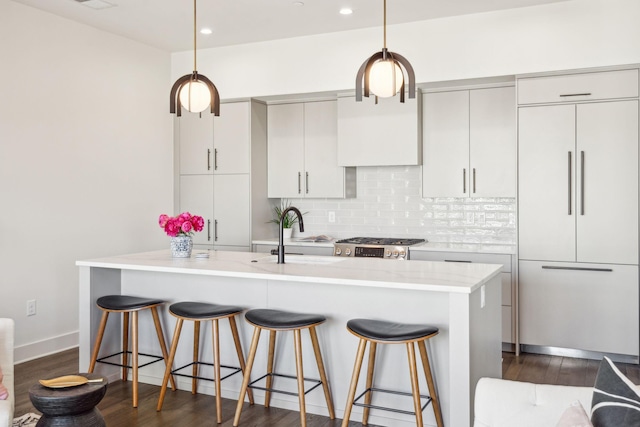 kitchen with sink, tasteful backsplash, dark hardwood / wood-style floors, paneled built in refrigerator, and pendant lighting