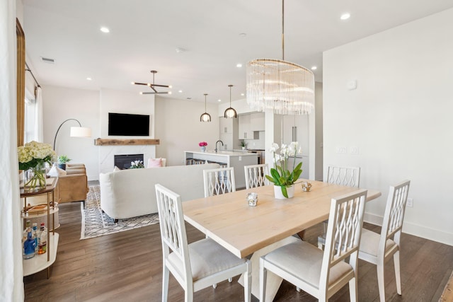 dining room featuring dark hardwood / wood-style flooring, sink, and a chandelier