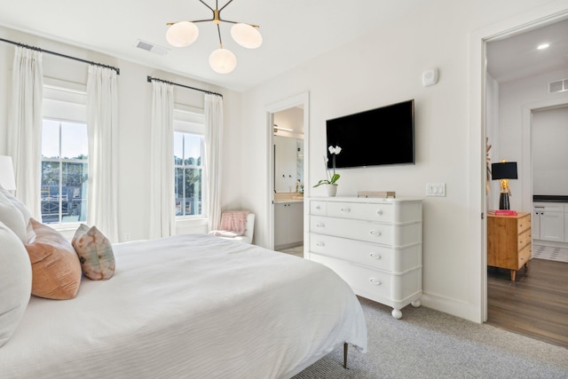 bedroom with ensuite bathroom and wood-type flooring