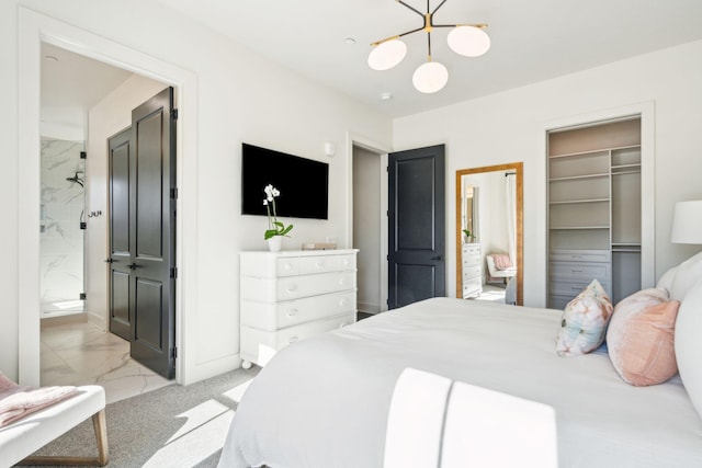 carpeted bedroom with connected bathroom, a spacious closet, a closet, and an inviting chandelier