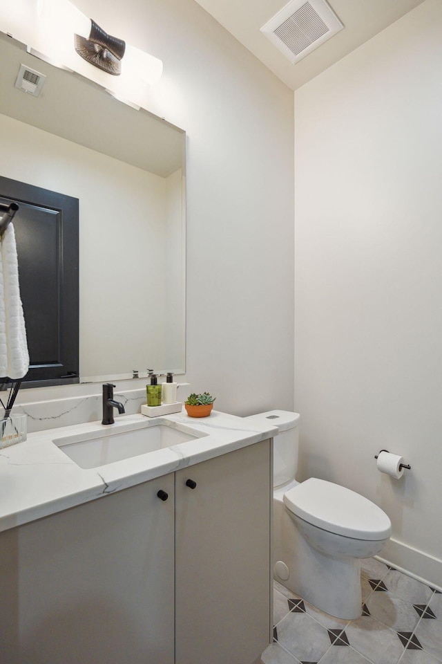 bathroom featuring tile patterned floors, vanity, and toilet