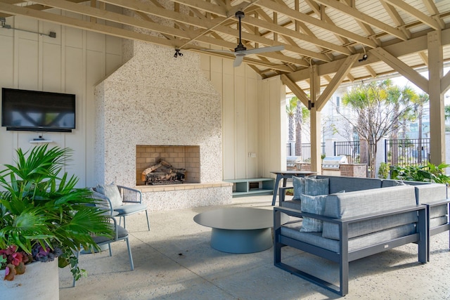 view of patio / terrace featuring ceiling fan, a large fireplace, exterior kitchen, and grilling area