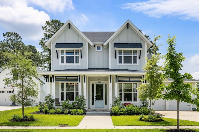 125 Integrity Ln, Charleston, SC 29492 - view of front of home with board and batten siding, a garage, driveway, a front lawn, and covered porch