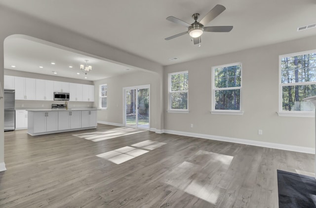 125 Integrity Ln, Charleston, SC 29492 - unfurnished living room with baseboards, light wood-style floors, recessed lighting, a ceiling fan, and a chandelier
