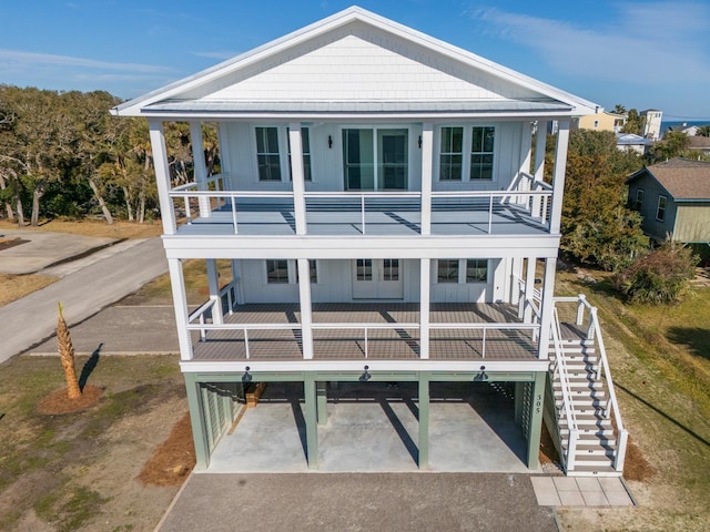 rear view of house with a balcony and a porch