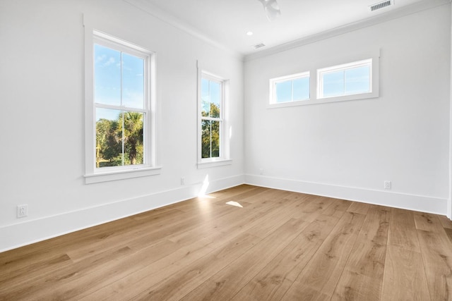 unfurnished room featuring ornamental molding and light wood-type flooring