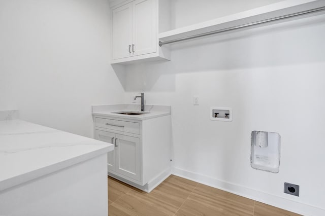 laundry area featuring hookup for a washing machine, sink, hookup for an electric dryer, and cabinets