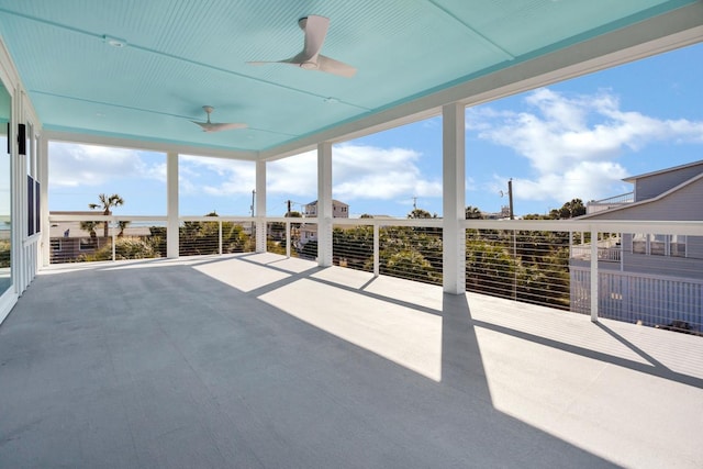 unfurnished sunroom featuring ceiling fan