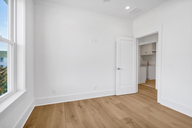 unfurnished room with crown molding and light hardwood / wood-style flooring