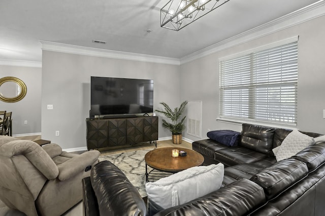 living room featuring wood-type flooring, ornamental molding, and a notable chandelier