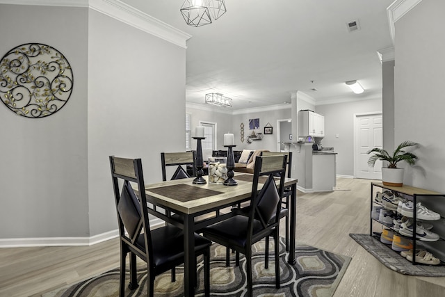 dining room featuring ornamental molding and light hardwood / wood-style flooring