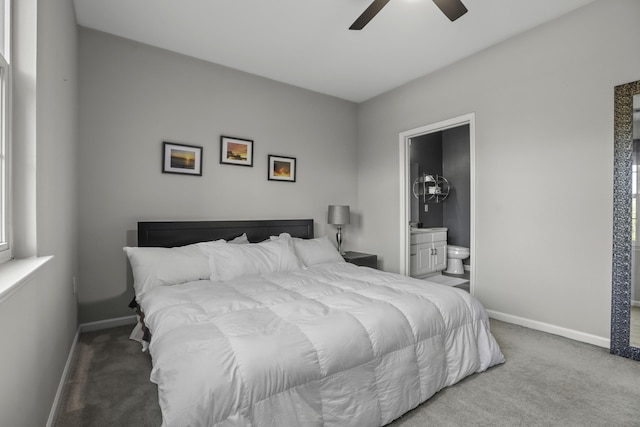 bedroom with ceiling fan, light colored carpet, and ensuite bathroom