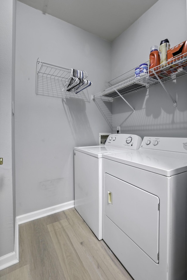 laundry area featuring light hardwood / wood-style floors and washing machine and clothes dryer