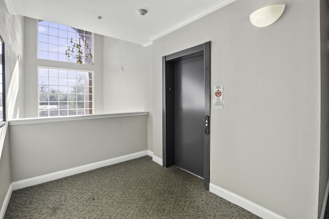 interior space with elevator, dark carpet, and ornamental molding