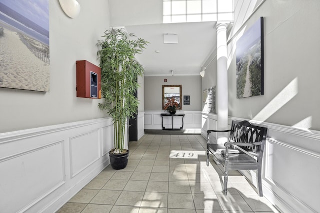 hall featuring ornamental molding and light tile patterned floors