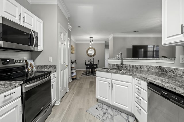 kitchen featuring stainless steel appliances, crown molding, sink, dark stone countertops, and white cabinetry