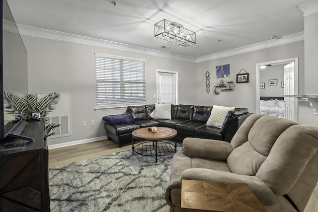 living room with hardwood / wood-style floors, ornamental molding, and an inviting chandelier