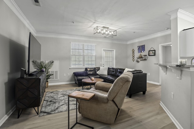 living room featuring light wood-type flooring, ornamental molding, and a chandelier