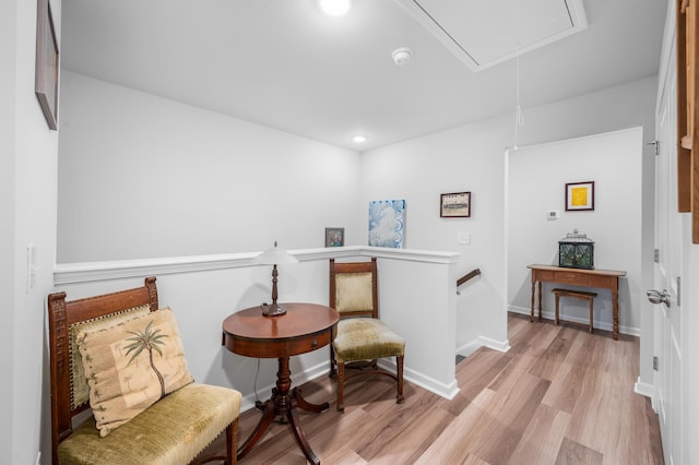 sitting room with an upstairs landing, attic access, recessed lighting, light wood-type flooring, and baseboards