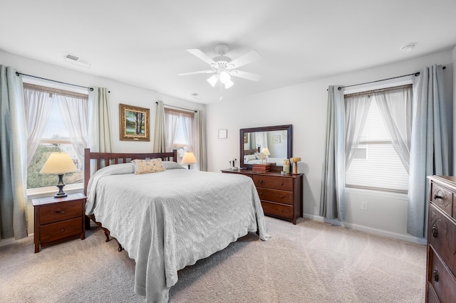 bedroom with baseboards, visible vents, a ceiling fan, and light colored carpet
