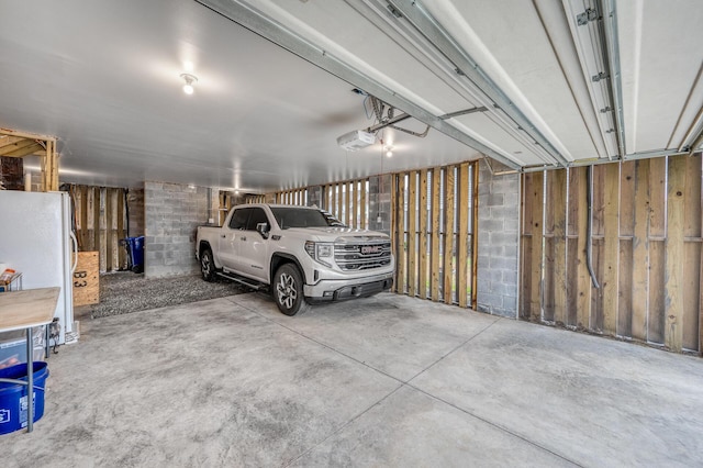 garage featuring a garage door opener and freestanding refrigerator