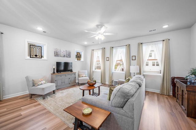 living room with a ceiling fan, light wood-style flooring, baseboards, visible vents, and recessed lighting