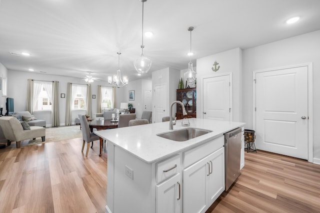 kitchen featuring white cabinets, dishwasher, a sink, light wood-type flooring, and open floor plan