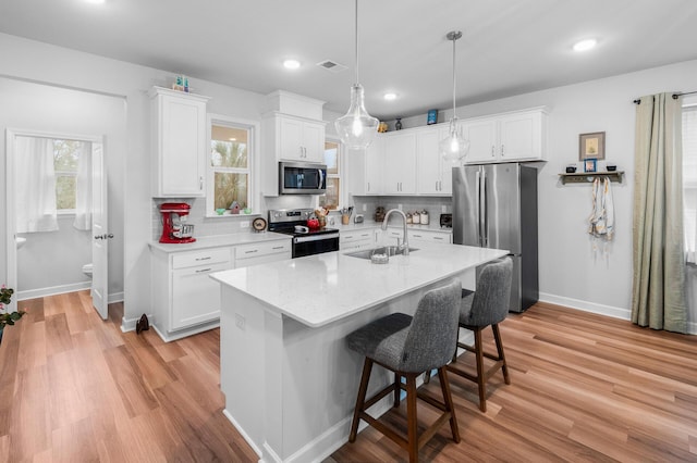 kitchen with visible vents, a sink, stainless steel appliances, and tasteful backsplash