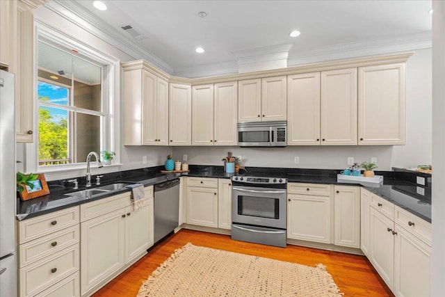 656 Coleman Blvd Unit 405, Mount Pleasant, SC 29464 - kitchen featuring a sink, stainless steel appliances, ornamental molding, cream cabinetry, and light wood-style floors