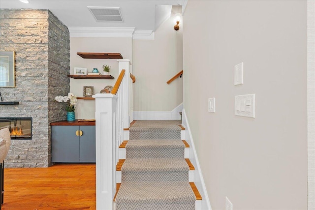 656 Coleman Blvd Unit 405, Mount Pleasant, SC 29464 - staircase featuring wood finished floors, ornamental molding, visible vents, a fireplace, and baseboards