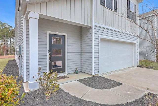 view of exterior entry featuring a garage and board and batten siding