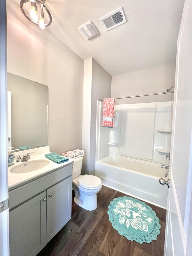 full bathroom with toilet, vanity, wood finished floors, and visible vents