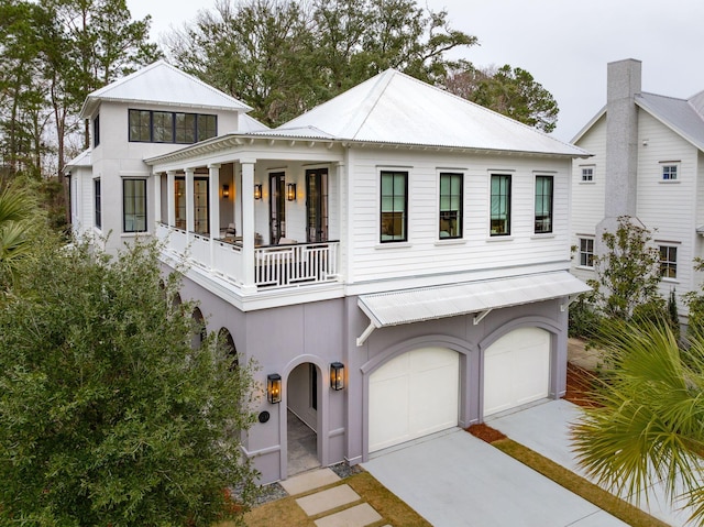 view of front of property featuring a balcony and a garage