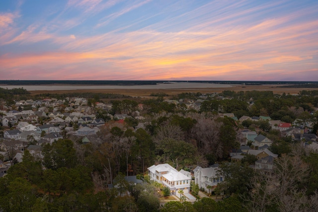 aerial view at dusk featuring a water view