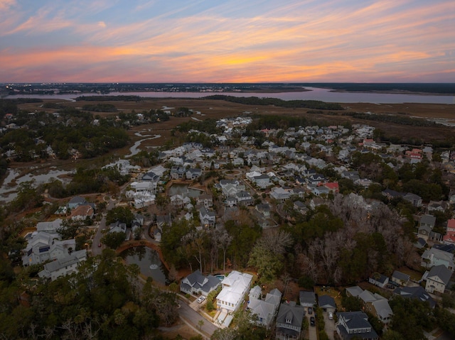 aerial view at dusk featuring a water view